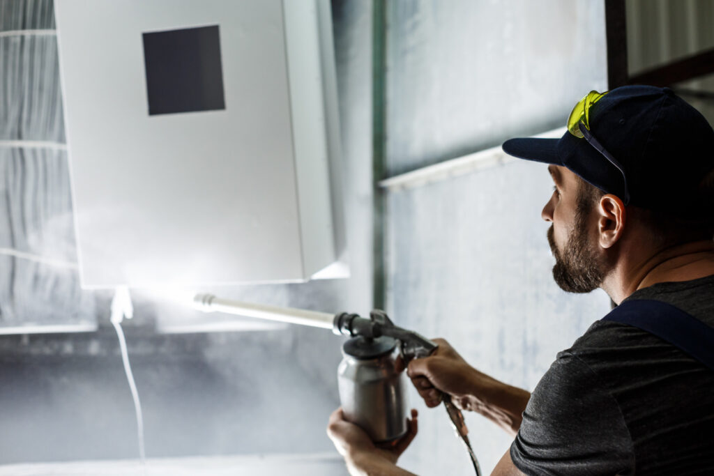 worker painting detail with air spray pistol